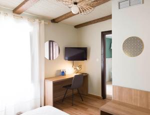 a bedroom with a desk and a tv and a chair at Hotel Juancaballo in Úbeda