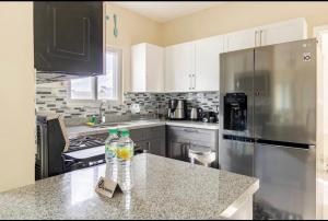 a kitchen with a stainless steel refrigerator and a counter top at Natty’s Cozy Beach house in Hanover Jamaica in Point