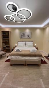 una grande camera da letto con un grande letto e un lampadario a braccio di N10 Apartment a Belgrado