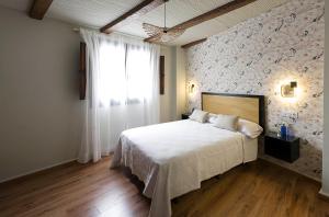a bedroom with a large bed with a floral wall at Hotel Juancaballo in Úbeda