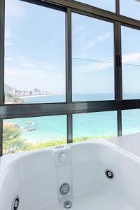 a white bath tub in front of a window at Beach Loft next to the Sheraton Leblon in Rio de Janeiro