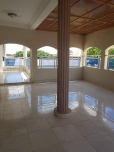 a large room with a column and a tile floor at Touray Guest House in Old Yundum