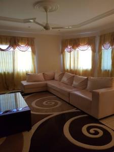 a living room with a couch and a rug at Touray Guest House in Old Yundum