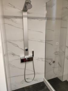 a shower with a glass door and a shower head at Comfy Apartment in Nafplio +22 photos