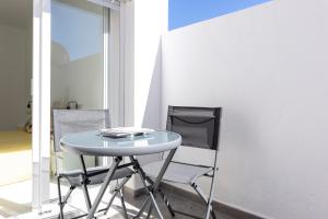 einen Glastisch und einen Stuhl in einem Zimmer in der Unterkunft Lovely 2-bedroom home in Pueblo Nuevo de Guadiaro in Guadiaro