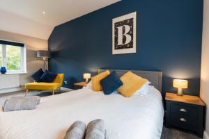 a bedroom with a large bed with blue walls at No40Barmouth-Modern,Spacious&Hot Tub in Barmouth