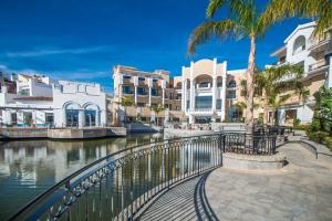a river with buildings and palm trees next to a canal at First Floor Apartment on La Torre Golf Resort- BO1212LT in Torre-Pacheco