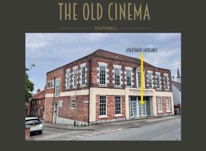 an old orange brick building on a city street at Spacious modern apartment. Centre of Southwell. in Southwell