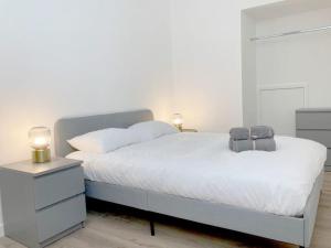 a bedroom with a white bed with a nightstand and a bed sidx sidx sidx at Spacious modern apartment. Centre of Southwell. in Southwell