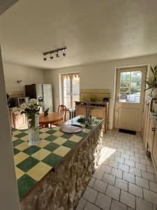 uma cozinha com uma bancada xadrez e um lavatório em Longère avec Piscine Couverte Chauffée privative de Avril à Septembre em Luzillé