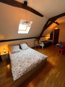 una camera con letto e soffitto con luce di Longère avec Piscine Couverte Chauffée privative de Avril à Septembre a Luzillé