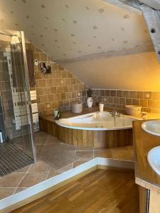 uma grande casa de banho com banheira e 2 lavatórios em Longère avec Piscine Couverte Chauffée privative de Avril à Septembre em Luzillé