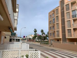 an empty street with two tall buildings and a crosswalk at Apartamento en la playa in Tavernes de Valldigna