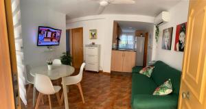 a living room with a table and a green couch at Apartamento en la playa in Tavernes de Valldigna