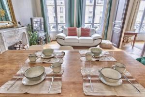 a dining room table with plates and dishes on it at Beautiful flat nearby Notre-Dame & Louvre - Welkeys in Paris