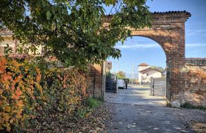 einen Torbogen in einer Backsteinmauer neben einer Straße in der Unterkunft La Rosa di Vinovo - Open Space in Vinovo