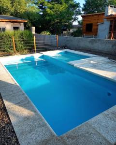 einen Pool mit blauem Wasser im Hinterhof in der Unterkunft Complejo Serena in Santa Rosa de Calamuchita