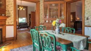 伊薩卡的住宿－William Henry Miller Inn，一间带桌子和绿色椅子的用餐室