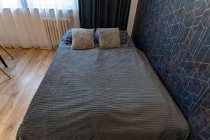 a bed with two pillows on it in a room at Chałubińskiego przytulne mieszkanie przy parku, blisko dworca in Radom