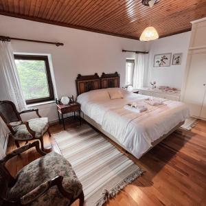 a bedroom with a large bed and a chair at The Lady of the Lake in Kalyvia