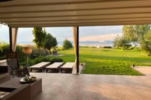 Luxury Lakefront Villa with Private Pier & Jacuzzi في بالاتونوشود: فناء مع أريكة وطاولة وميدان أخضر