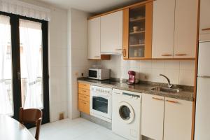 a kitchen with a washing machine and a microwave at Vut RAQUEL in Astorga