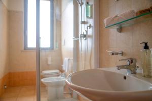 a bathroom with a sink and a toilet and a window at Hotel Royal in Giulianova
