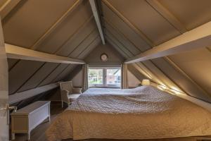 ein Schlafzimmer mit einem großen Bett im Dachgeschoss in der Unterkunft Rustig gelegen woning in het groen nr 140 in Simpelveld
