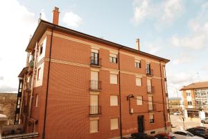 a red brick building on a city street at Vut RAQUEL in Astorga