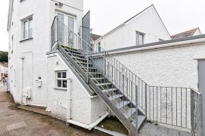 a staircase on the side of a white building at 3-bed in Mumbles with free parking & sea views in The Mumbles