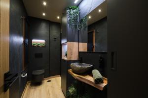 a bathroom with a bowl sink and black walls at El Harapan - Sumérgete en una selva a pie de playa - Grupo Querbes in Gijón
