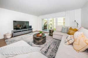 a living room with a white couch and a tv at White Dunes Condo in Clearwater Beach