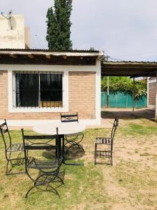 une table et deux chaises dans la cour dans l'établissement Cabañas Vista Andes VI, à Luján de Cuyo