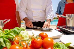 a man preparing food on a cutting board with tomatoes at Hotel Villa Romana in Porto Empedocle