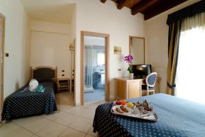 a hotel room with a bed with a tray of food on it at Hotel Villa Romana in Porto Empedocle
