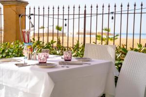 a white table with chairs and a view of the beach at Hotel Villa Romana in Porto Empedocle