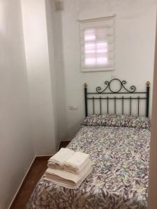 - une chambre avec un lit et des serviettes dans l'établissement Apartamento rural cerca del centro, à Caudete