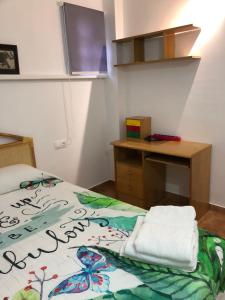 a small room with a bed with a desk and a desk at Apartamento rural cerca del centro in Caudete