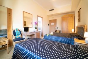 a hotel room with two beds and a desk at Hotel Villa Romana in Porto Empedocle
