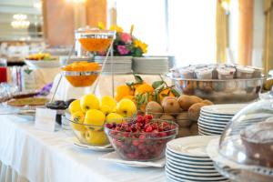 a table with plates and bowls of fruit on it at Hotel Villa Romana in Porto Empedocle