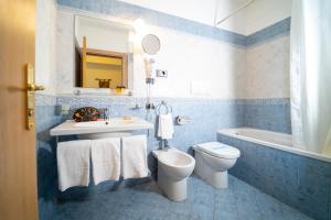 a blue and white bathroom with a toilet and a sink at Hotel Villa Romana in Porto Empedocle