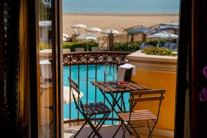 a balcony with a table and chairs next to a pool at Hotel Villa Romana in Porto Empedocle