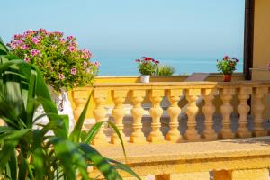 a balcony with potted plants and flowers on it at Hotel Villa Romana in Porto Empedocle