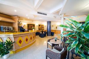 a man standing at the bar in a hotel lobby at Hotel Villa Romana in Porto Empedocle