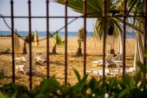 a group of chairs and umbrellas on a beach at Hotel Villa Romana in Porto Empedocle