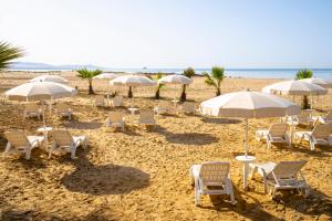 a group of chairs and umbrellas on a beach at Hotel Villa Romana in Porto Empedocle