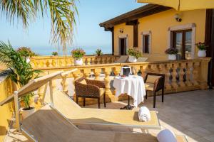 a balcony of a house with a table and chairs at Hotel Villa Romana in Porto Empedocle