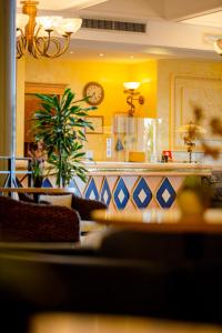 a living room with a clock on a yellow wall at Hotel Villa Romana in Porto Empedocle