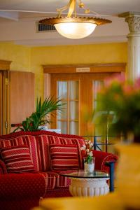 a living room with a red couch and a table at Hotel Villa Romana in Porto Empedocle