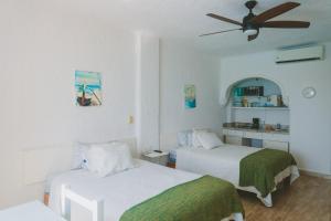 a bedroom with two beds and a ceiling fan at Cancun Plaza Condo Ocean front in Cancún